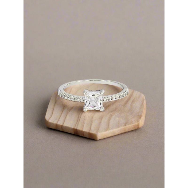 Silver ring with a central diamond and smaller diamonds on a white background